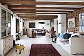 Offener Wohnbereich mit rustikaler Holzbalkendecke in skandinavischem Stil