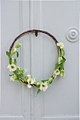 Rustic wreath made from rusty wire and tulips on cupboard door