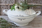 Tag, anemone and larch twigs on soup tureen