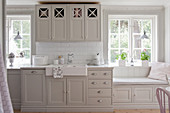 Bright country-house kitchen with grey panelled cabinets and windowseat