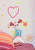 Rag doll leaning against wall decorated with washi-tape shapes