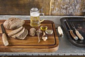 Sliced loaf and beer mug with pewter lid on wooden tray