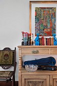 Open violin case and books on antique dresser