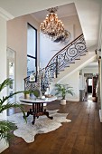 Curved staircase and chandelier in reception hall
