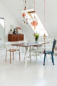Dining table, various chairs and pretty suspended ornaments