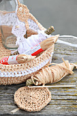 Crocheted raffia bread basket and glass bottle decorated with knitted raffia fish