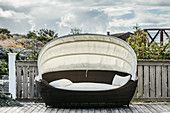 Oval lounger with awning on veranda
