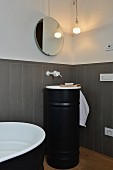 Grey wainscoting, round mirror and black sink unit in modernised bathroom