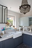 Vintage-style kitchen with grey cabinets and chandelier