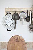 Old kitchen utensils hung from board on wall