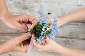 Hands holding posy of forget-me-nots