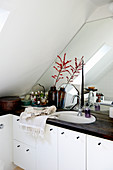 Vintage ornaments in bathroom under sloping ceiling with mirrored wall
