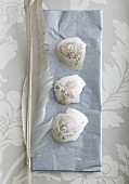 Decorated pieces of egg shell and feathers on grey napkin