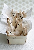 Easter bunny biscuits, white feathers and napkin in chip wood basket
