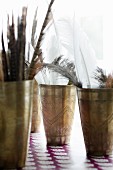 Feathers in ornate pewter beakers