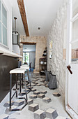 Blick durch offene Tür in Hauseingang und Küche mit alten Fliesen