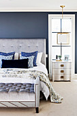 Elegant bedroom with gray upholstered bed with upholstered bench