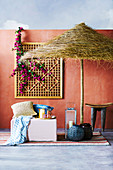 Oriental seat under the parasol against a red wall