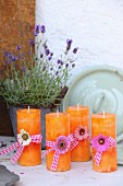 Orange candles decorated with flowers and ribbons