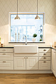 White country-house kitchen with diamond-patterned wallpaper and large window