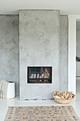 Basket of firewood next to fireplace in concrete wall