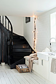 Schwarze Treppe in weißer Küche mit Sitzbank in der Küchenzeile
