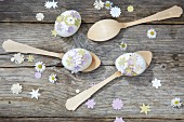 Eggs decorated with punched paper stars on wooden spoons