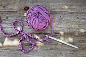 Row of chain stitch and ball of purple T-shirt yarn