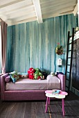 Rosa Bett mit Kuscheltieren vor türkisfarbener Wand im Mädchenzimmer, seitlich Leiter an Hochbett
