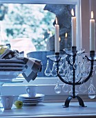 Lit candles in black candelabra with glass pendants