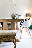 Modern shell chairs and old stool around wooden table
