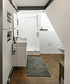 White bathroom with brown tiled floor and exposed brickwork
