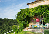 Bunt gestrichene Gartenstühle und Lampions auf der Terrasse