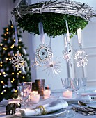 Suspended wreath festively decorated with various silver stars and snowflakes