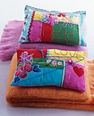 Colourful patchwork cushions on woollen blankets