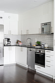 Stainless steel appliances in minimalist kitchen