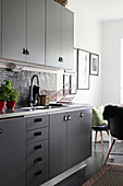 Kitchen with leather handles on grey cupboards and drawers