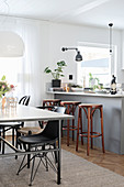 Dining table next to grey kitchen counter with bar stools