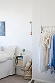 Suspended clothes rail in white bedroom