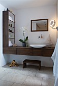 Wooden washstand and shelving in bathroom