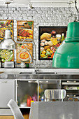 Edelstahl Küche mit gerahmten Bildern an weisser Ziegelwand
