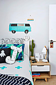 Boy's room with bed, bedside table and car motif on the wall