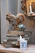 Still-life arrangement with stuffed squirrel on stack of vintage books