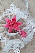 Folded paper flowers on lace and fabric rosette