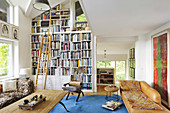 Bookcase with library ladder and leather couch in vintage-style living room