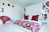 Weißes Schlafzimmer mit roten Farbakzenten und Blumenmuster