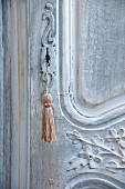 Key with tassel in artistically carved, antique wooden door