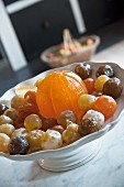 Candied fruits in white china dish on marble surface