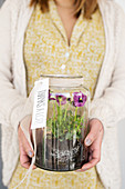 Woman holding jar of violas as thank-you gift