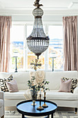 Pale sofa set and chandelier in elegant living room
